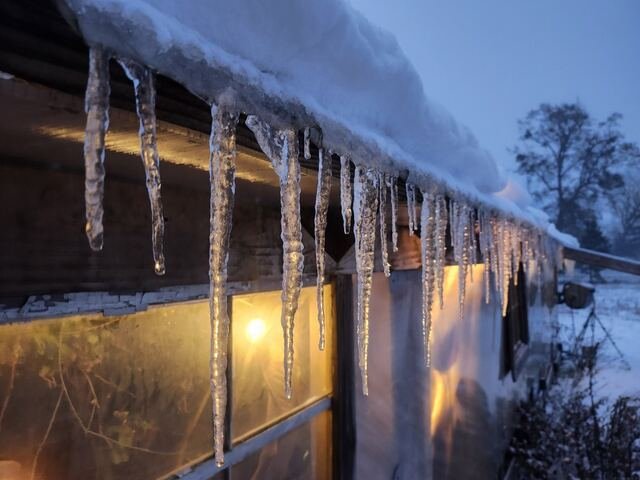 Icicles on the greenhouse roof, lit from inside